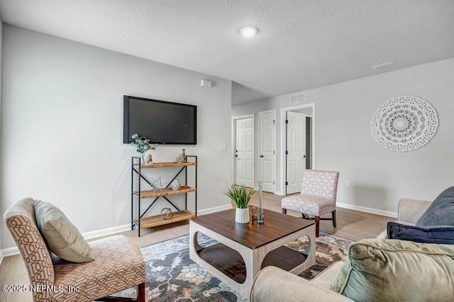 5454 Amazon Ave, Jacksonville, FL 32254 - living area featuring light wood finished floors, baseboards, visible vents, and a textured ceiling