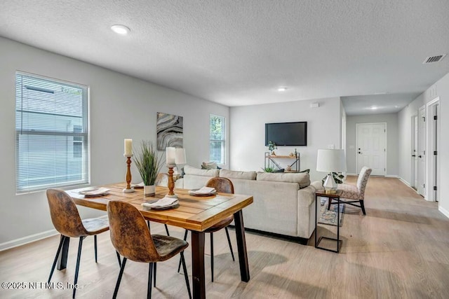 5454 Amazon Ave, Jacksonville, FL 32254 - dining area with light wood finished floors, baseboards, visible vents, and a textured ceiling