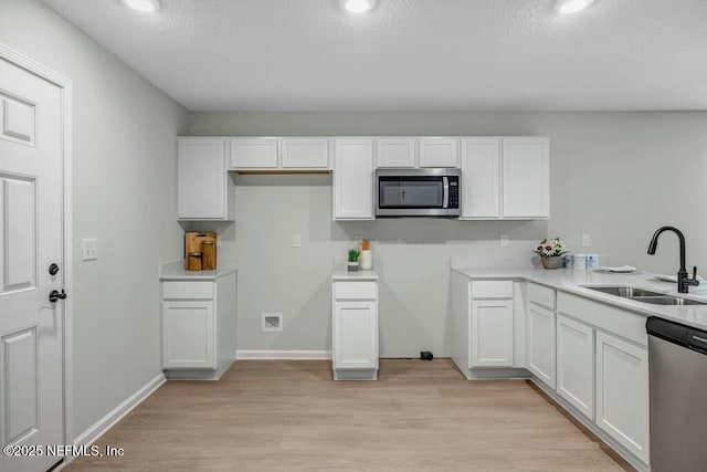 5454 Amazon Ave, Jacksonville, FL 32254 - kitchen with light wood-style floors, white cabinetry, stainless steel appliances, and a sink
