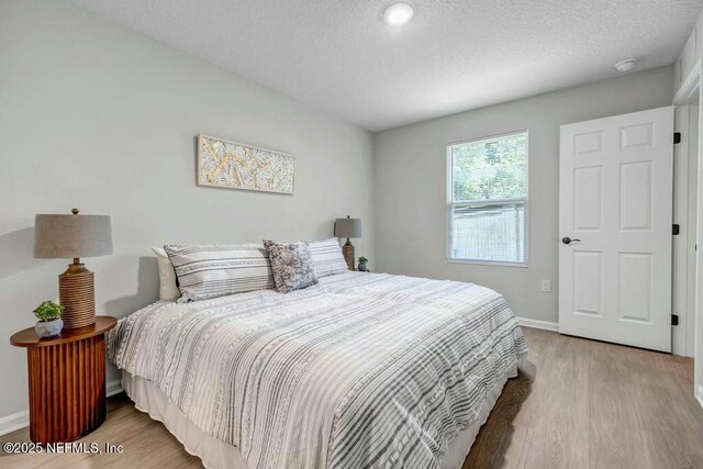 5454 Amazon Ave, Jacksonville, FL 32254 - bedroom with wood finished floors, a textured ceiling, and baseboards