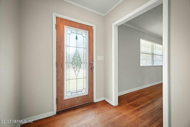 foyer entrance featuring baseboards, ornamental molding, and wood-type flooring