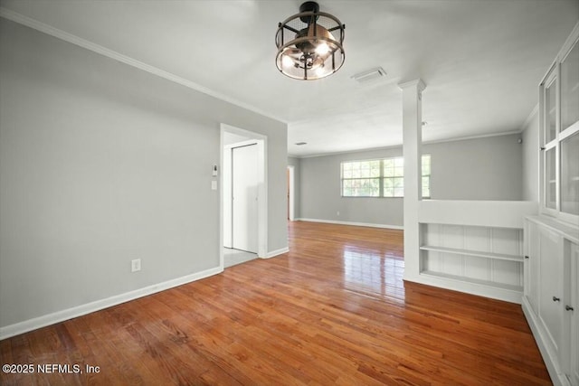 unfurnished room featuring baseboards, ornamental molding, and wood finished floors
