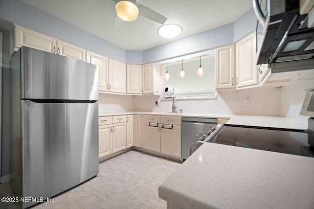 kitchen featuring decorative backsplash, a ceiling fan, light countertops, a sink, and stainless steel appliances