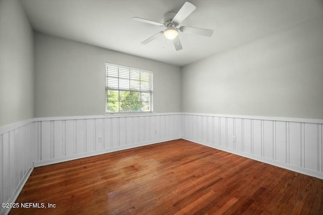 unfurnished room featuring wainscoting, ceiling fan, and wood finished floors