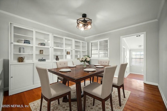 dining area featuring baseboards, ornamental molding, and wood finished floors