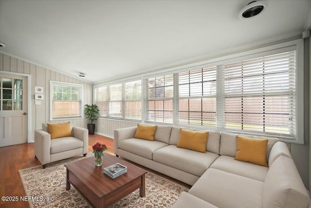 living room with vaulted ceiling, ornamental molding, and wood finished floors