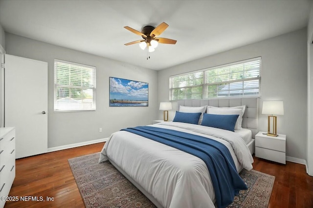 bedroom featuring baseboards, multiple windows, and wood finished floors