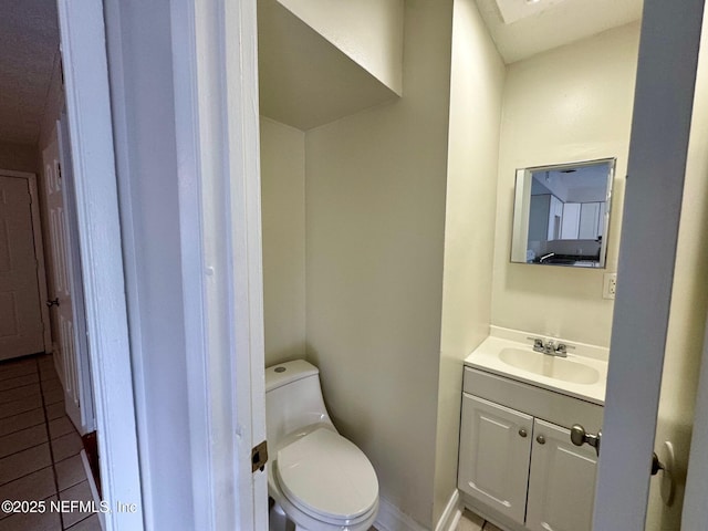 half bath featuring toilet, vanity, and tile patterned floors
