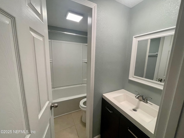 full bath featuring toilet, shower / bathing tub combination, tile patterned flooring, a textured wall, and vanity