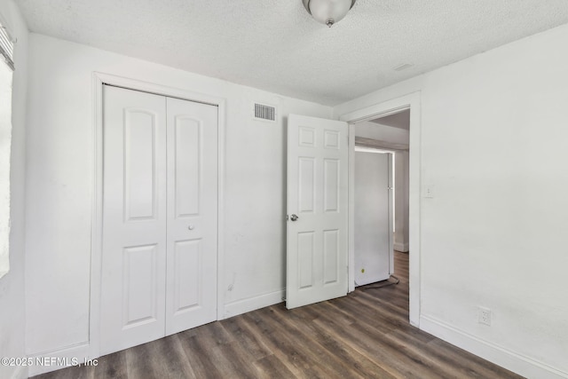 1330 Barnett St, Jacksonville, FL 32209 - unfurnished bedroom with dark wood-style floors, a closet, visible vents, baseboards, and a textured ceiling