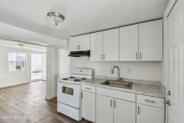 1330 Barnett St, Jacksonville, FL 32209 - kitchen with under cabinet range hood, light countertops, white cabinets, white range with electric stovetop, and a sink