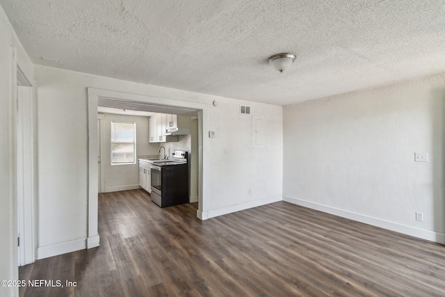 1330 Barnett St, Jacksonville, FL 32209 - unfurnished living room featuring dark wood-style floors, a textured ceiling, a sink, and baseboards