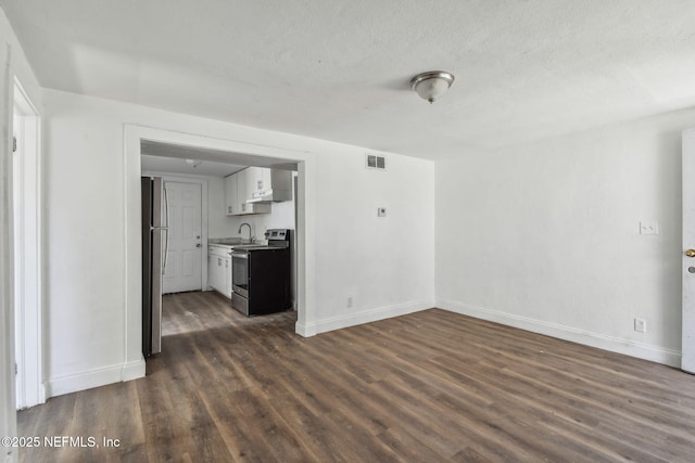1330 Barnett St, Jacksonville, FL 32209 - unfurnished living room featuring dark wood-style flooring, visible vents, a sink, and baseboards