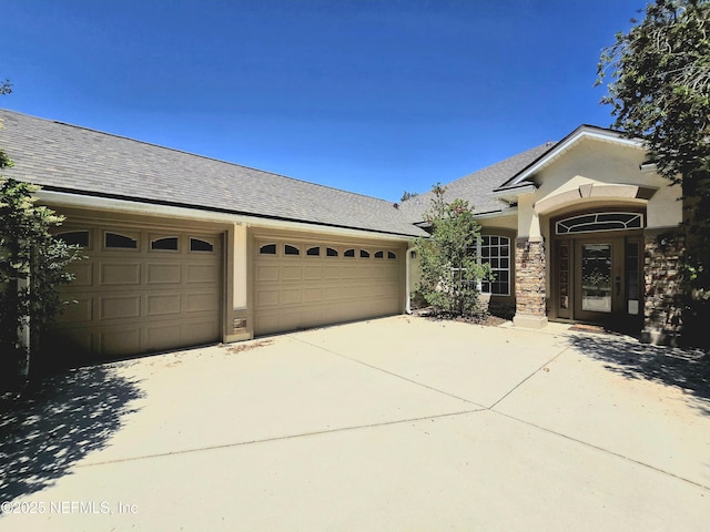 ranch-style house featuring a garage, roof with shingles, stucco siding, and concrete driveway