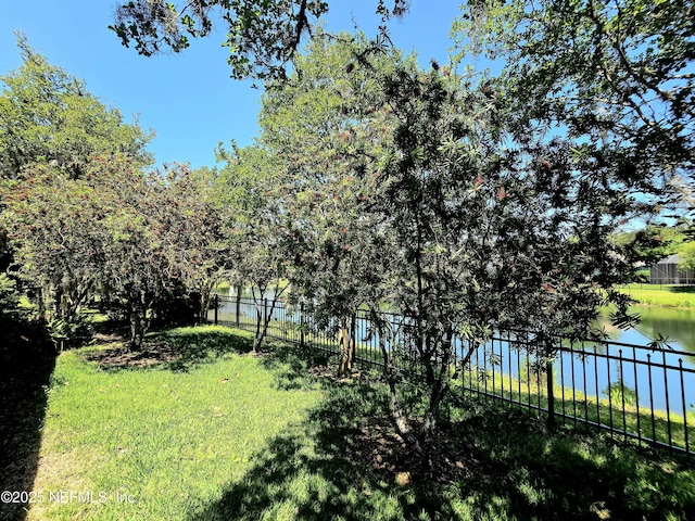 view of yard with fence and a water view