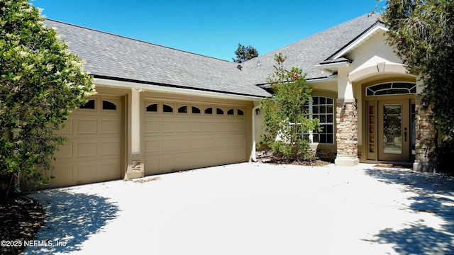 view of front of home featuring concrete driveway, roof with shingles, and a garage