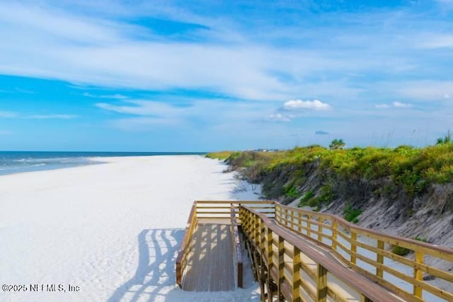 surrounding community with a water view and a beach view