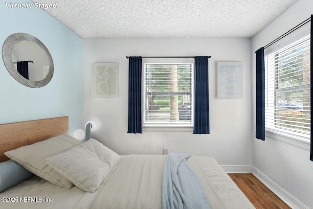 100 Fairway Park Blvd Unit 1101, Ponte Vedra Beach, FL 32082 - bedroom featuring wood finished floors, a textured ceiling, and multiple windows