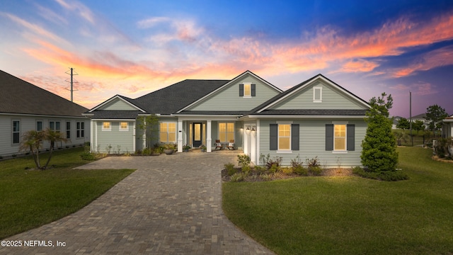 view of front of home featuring decorative driveway and a front yard