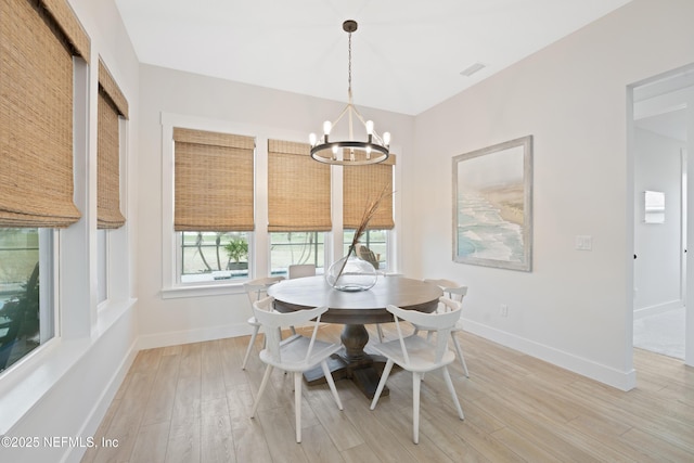 dining space featuring baseboards, a notable chandelier, visible vents, and light wood-type flooring
