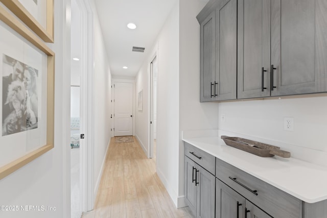 corridor featuring recessed lighting, baseboards, visible vents, and light wood-style flooring