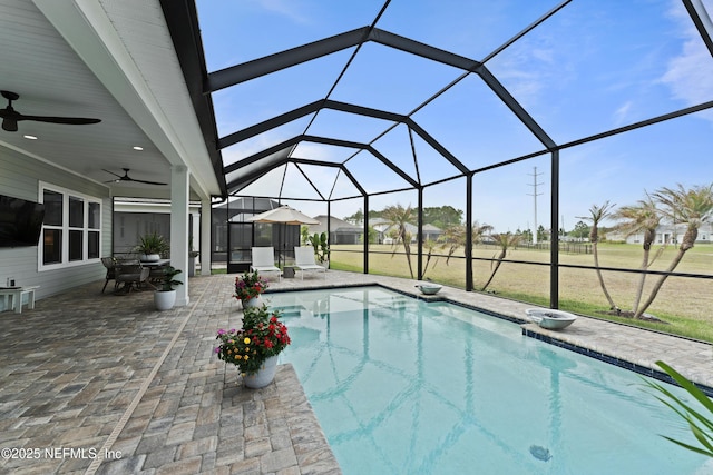 outdoor pool featuring glass enclosure, a patio, a ceiling fan, and outdoor dining area