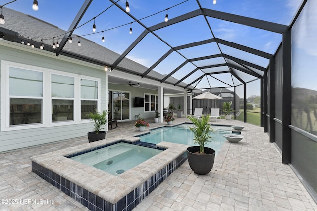 view of pool featuring a lanai, a pool with connected hot tub, a ceiling fan, and a patio area