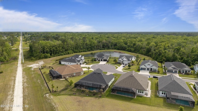 drone / aerial view featuring a residential view, a view of trees, and a water view