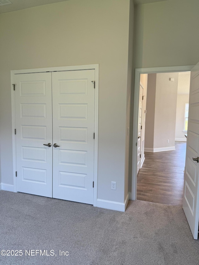 8340 Helmsley Blvd, Jacksonville, FL 32219 - unfurnished bedroom featuring baseboards, carpet, a towering ceiling, and a closet