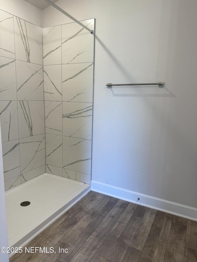 8340 Helmsley Blvd, Jacksonville, FL 32219 - bathroom with wood finished floors, a tile shower, and baseboards