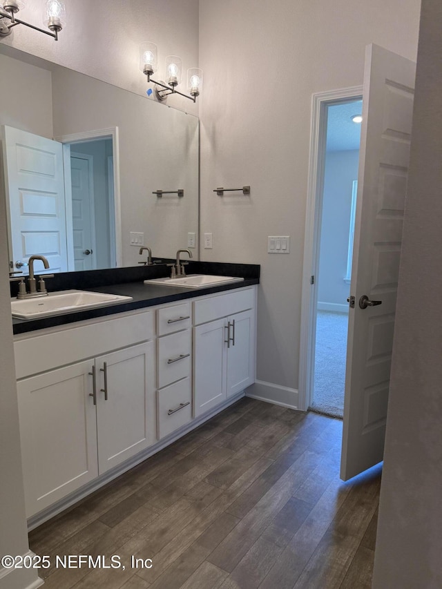 8340 Helmsley Blvd, Jacksonville, FL 32219 - bathroom with wood finished floors, double vanity, and baseboards