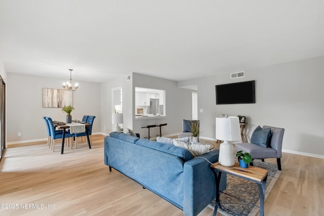 10136 Leisure Ln N Unit 26, Jacksonville, FL 32256 - living room featuring light wood-style floors, a chandelier, and baseboards