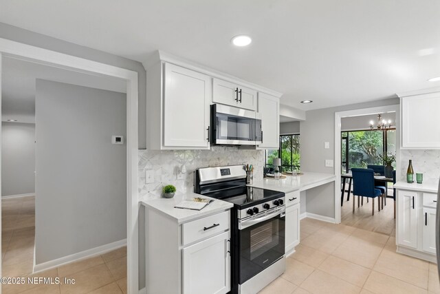 10136 Leisure Ln N Unit 26, Jacksonville, FL 32256 - kitchen with appliances with stainless steel finishes, tasteful backsplash, a chandelier, light countertops, and light tile patterned floors