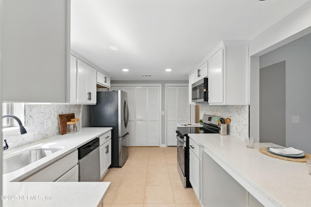 10136 Leisure Ln N Unit 26, Jacksonville, FL 32256 - kitchen featuring appliances with stainless steel finishes, a sink, decorative backsplash, white cabinetry, and recessed lighting