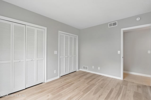 10136 Leisure Ln N Unit 26, Jacksonville, FL 32256 - unfurnished bedroom with light wood-type flooring, two closets, and baseboards