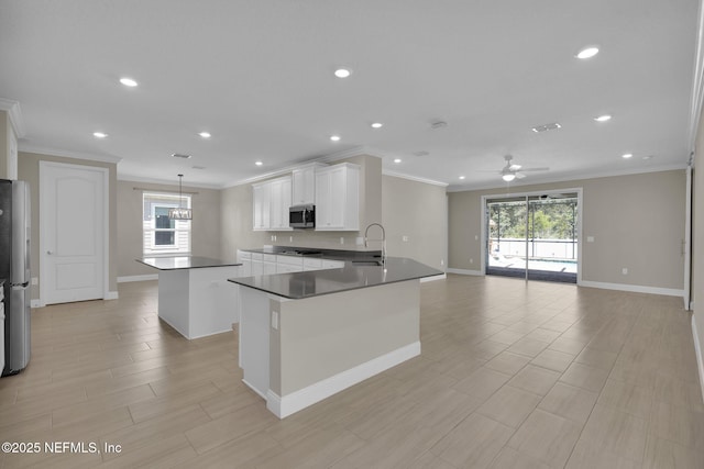 251 Dosel Ln, Saint Augustine, FL 32095 - kitchen featuring crown molding, ceiling fan, baseboards, appliances with stainless steel finishes, and a kitchen island