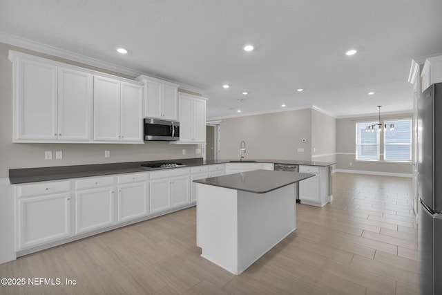 251 Dosel Ln, Saint Augustine, FL 32095 - kitchen with stainless steel appliances, an inviting chandelier, ornamental molding, a peninsula, and white cabinetry