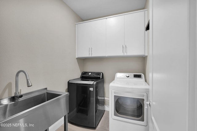 251 Dosel Ln, Saint Augustine, FL 32095 - washroom featuring separate washer and dryer, cabinet space, a sink, and light wood-style floors