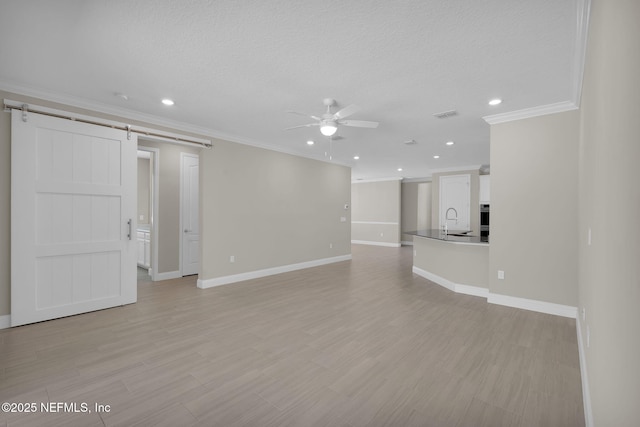 251 Dosel Ln, Saint Augustine, FL 32095 - unfurnished living room featuring a barn door, crown molding, baseboards, and ceiling fan