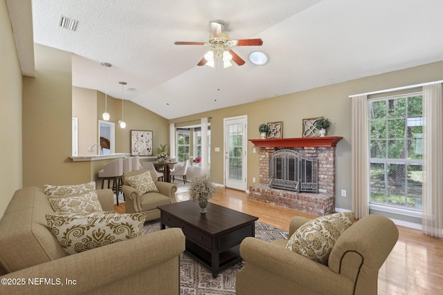 4443 Staple Ct, Middleburg, FL 32068 - living area with vaulted ceiling, plenty of natural light, wood finished floors, ceiling fan, and a fireplace