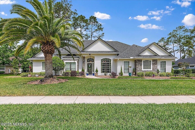 3241 Sequoyah Cir, Saint Johns, FL 32259 - view of front of property featuring stone siding, a shingled roof, a front yard, and stucco siding