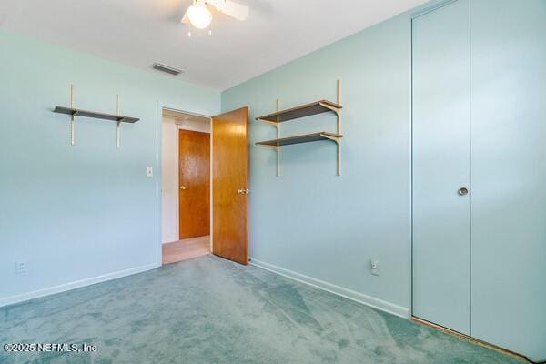 unfurnished bedroom featuring carpet flooring, a ceiling fan, visible vents, and baseboards
