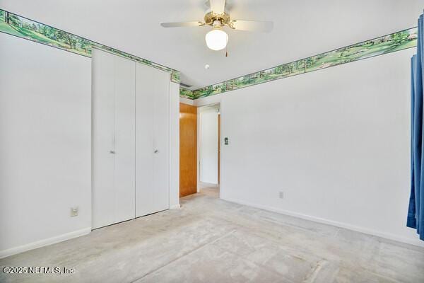 unfurnished bedroom with unfinished concrete floors, baseboards, a ceiling fan, and a closet