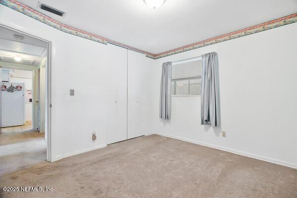 carpeted empty room featuring visible vents and baseboards