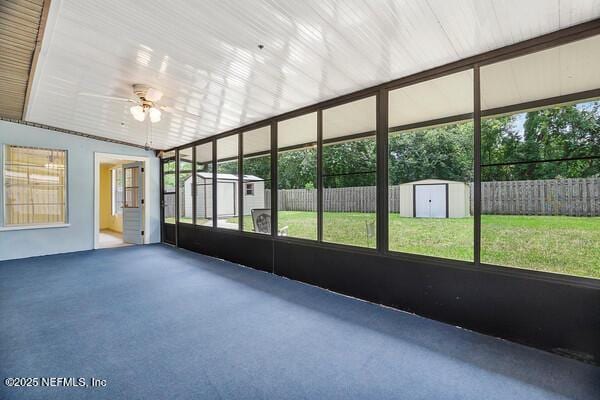 unfurnished sunroom with ceiling fan