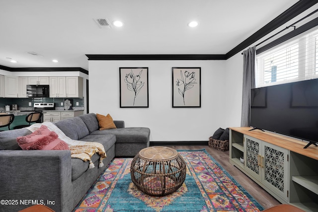 living area with visible vents, crown molding, wood finished floors, baseboards, and recessed lighting