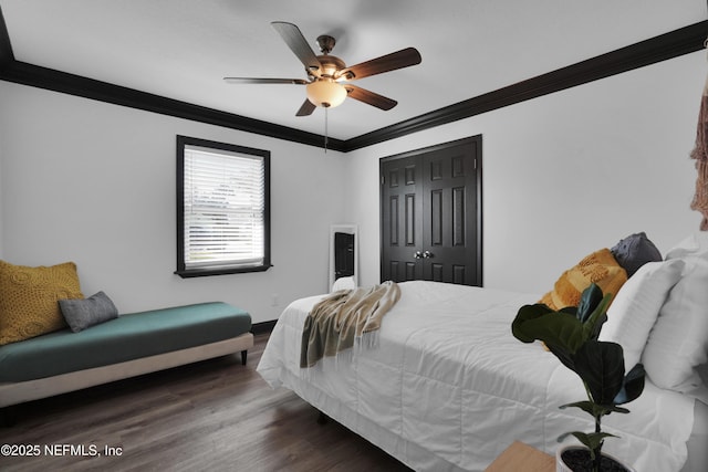 bedroom with a closet, ornamental molding, wood finished floors, baseboards, and a ceiling fan
