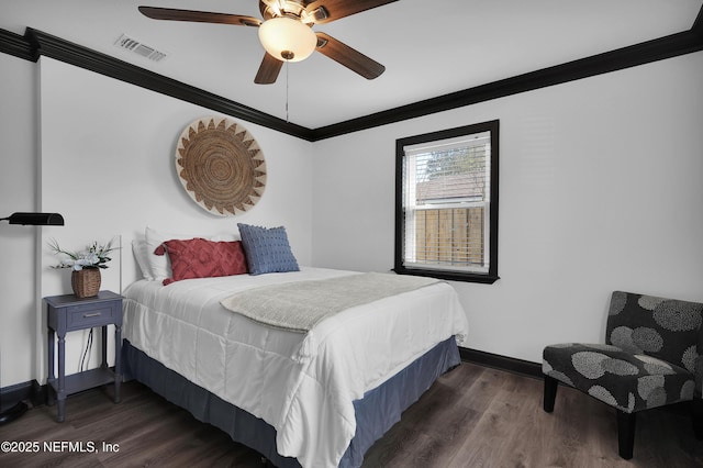 bedroom featuring visible vents, crown molding, wood finished floors, baseboards, and a ceiling fan