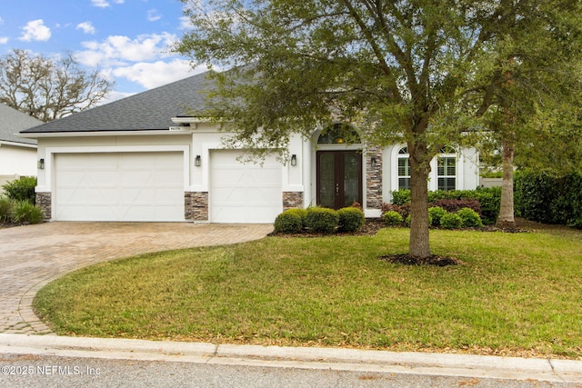 view of front facade featuring decorative driveway, stone siding, french doors, an attached garage, and stucco siding