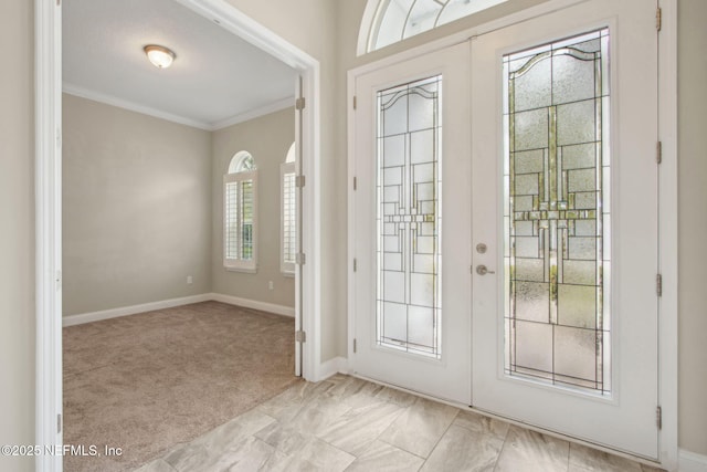 doorway featuring light carpet, baseboards, ornamental molding, and french doors